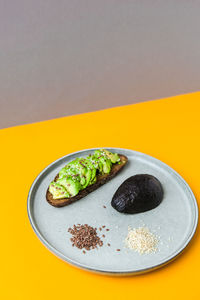 Ingredients for healthy avocado toast. ripe hass avocado, wholegrain bread, sesame flax seeds. vegan 