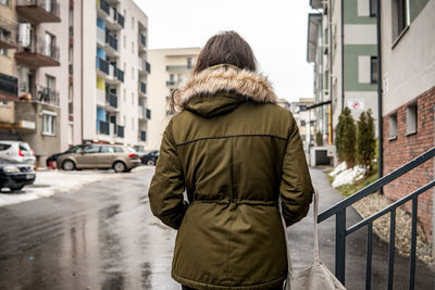 Rear view of woman on city street during winter