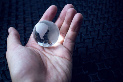 Close-up of hand holding crystal ball