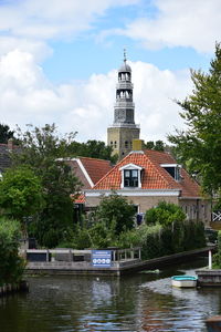 Canal by building against sky