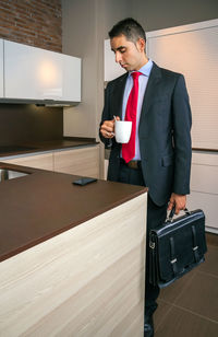 Full length of man holding coffee cup