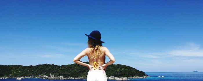 Rear view of woman looking at sea against sky