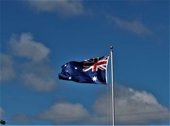 Low angle view of flag flags against sky