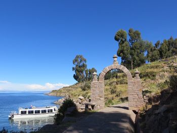 Castle by sea against clear blue sky