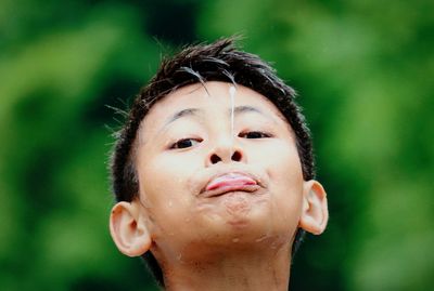 Close-up portrait of boy spiting water