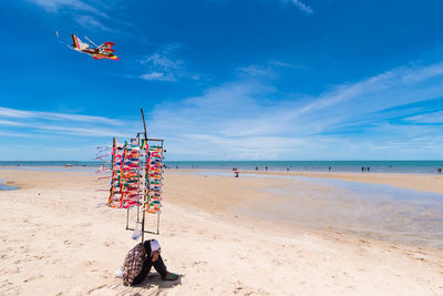 Side view of man sitting at beach