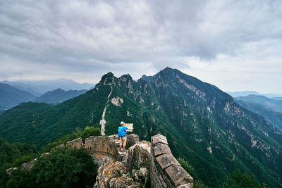 High angle view of man holding map while standing on great wall of china