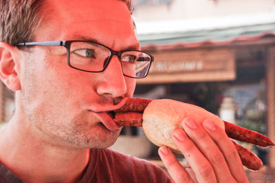 Close-up of young man eating food outdoors