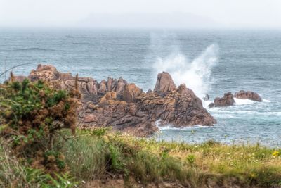 Scenic view of rocks in sea against sky