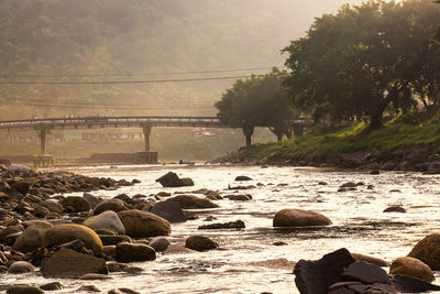 Rocks by river against sky