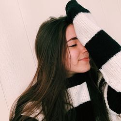 Portrait of young woman against white wall