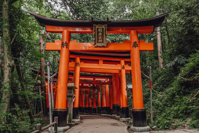Exterior of temple by building in forest