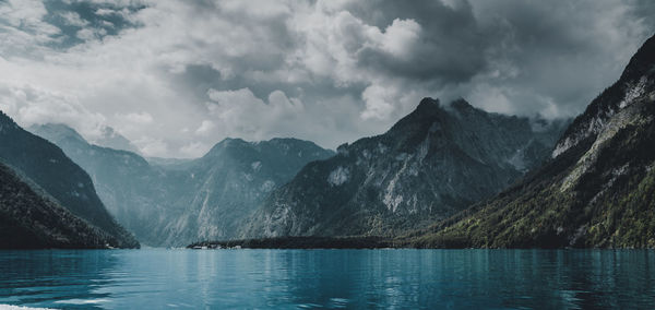 Scenic view of lake by mountains against sky