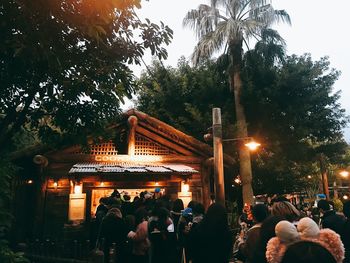 People at illuminated temple against sky at night