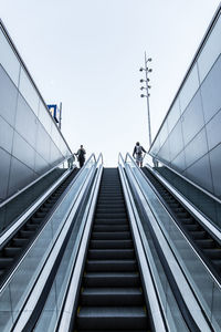 Low angle view of escalator against sky