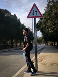 Side view of man standing on road
