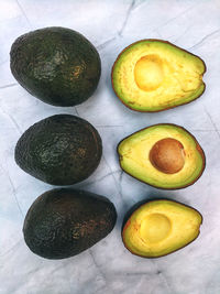 Fresh avocado with herbs and lemons lies on the table on white background. flat lay. top view.