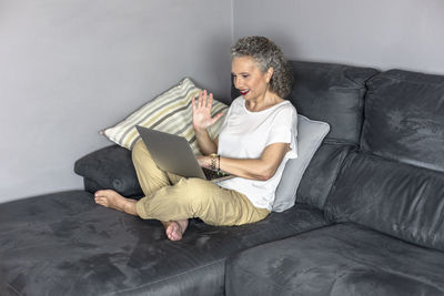 Young woman sitting on sofa at home