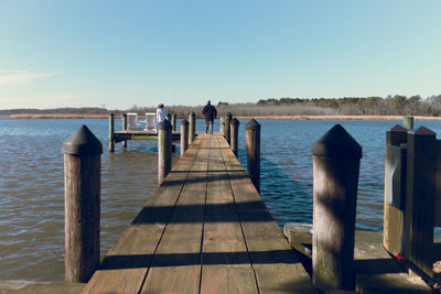 Wooden pier over sea against sky