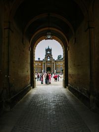 People in courtyard seen from tunnel