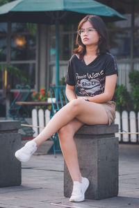 Asian teen sitting in public place with summer style