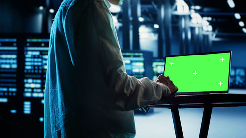 Rear view of man using laptop at airport