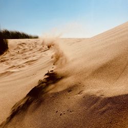 Sand dunes in desert against clear sky