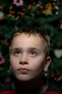 Close-up of thoughtful boy against christmas tree