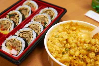 High angle view of gimbap with macaroni and cheese on table