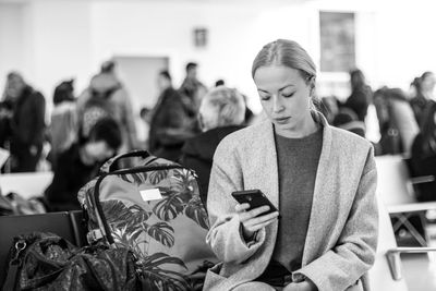 Woman using mobile phone at airport