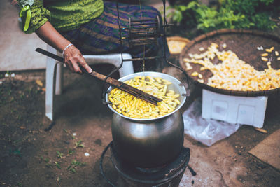 Midsection of person preparing food on barbecue grill