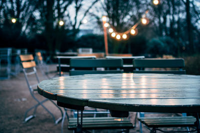 Empty chairs and tables at outdoor restaurant during dusk