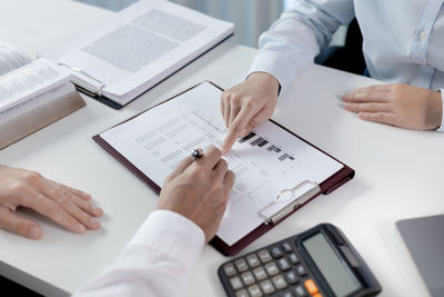 Midsection of businessman working on table