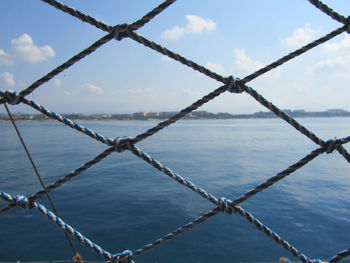 Close-up of chain on sea against sky