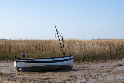 Boat moored on land against clear sky