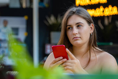 Portrait of a beautiful young woman holding smart phone