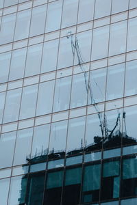 Low angle view of glass building against sky