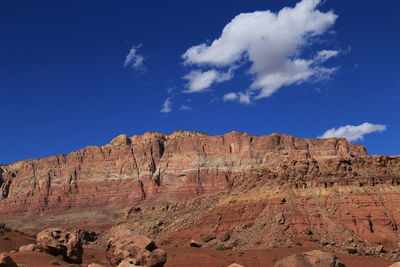 Low angle view of rocky mountain against blue sky
