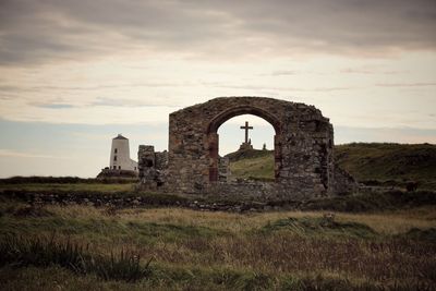 Old ruin on field against sky