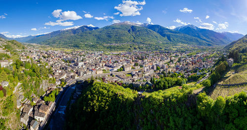 Panoramic view of townscape and mountains against sky