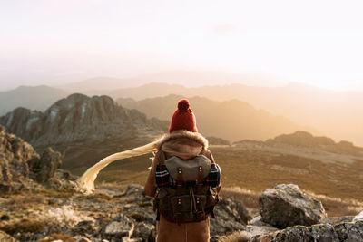 Rear view of man looking at mountain against sky