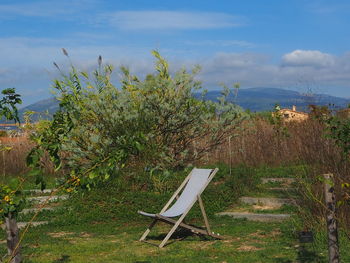 View of chair on field against sky