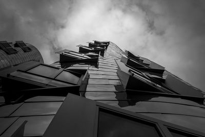 Low angle view of modern building against cloudy sky