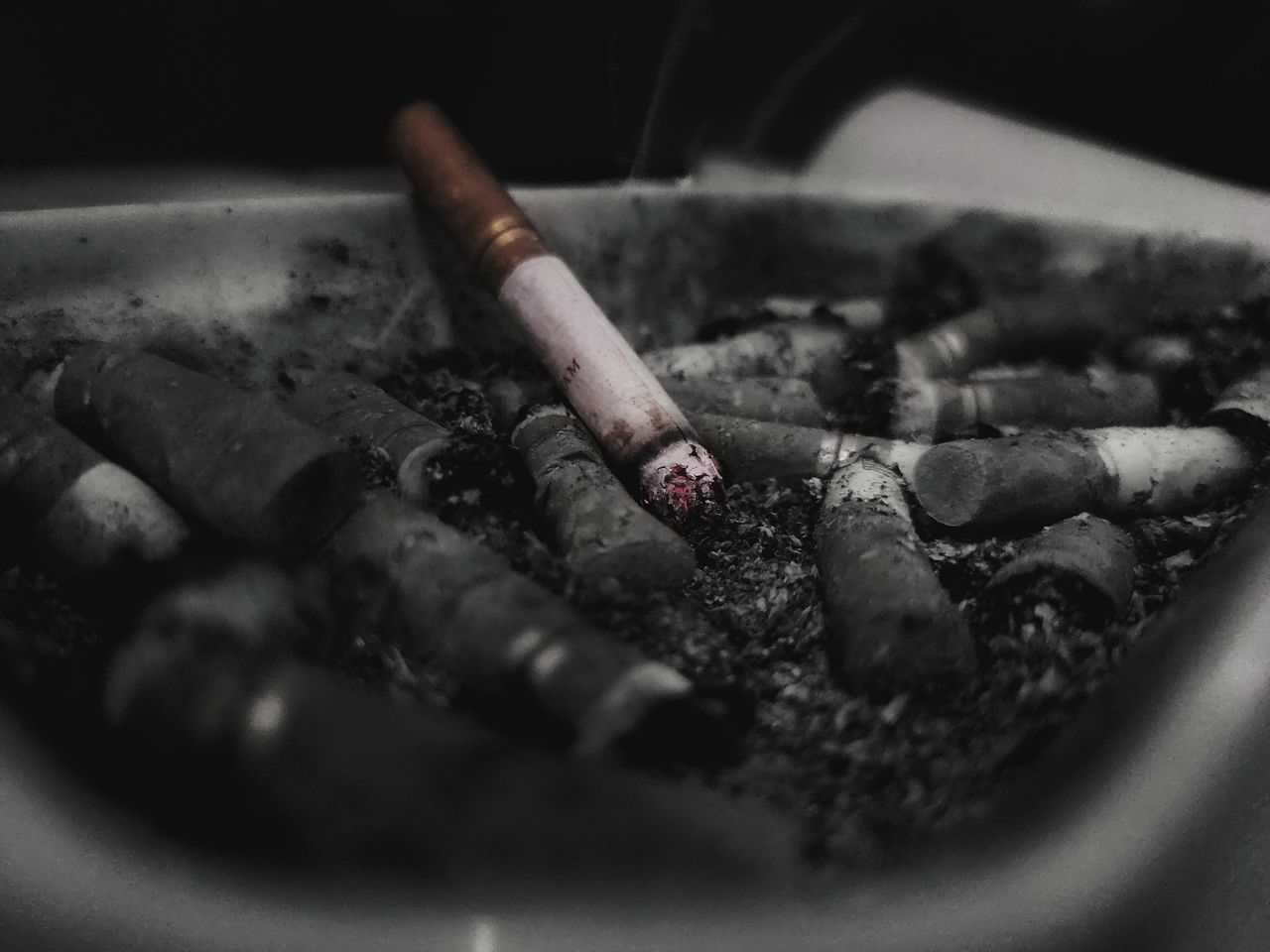 CLOSE-UP OF CIGARETTE SMOKING ON FLOOR