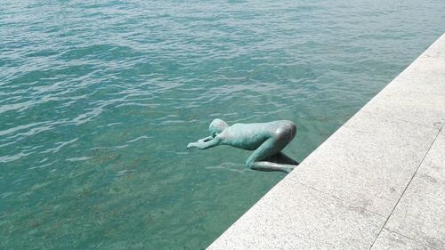 High angle of statue at shore against sea