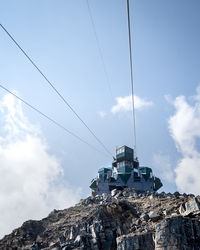Low angle view of communications tower on mountain against sky