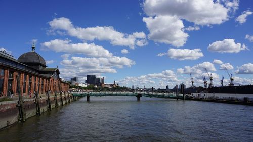 Bridge over river against buildings in city