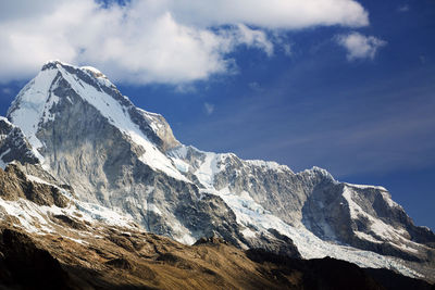 Low angle view of snowcapped mountain against cloudy sky