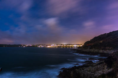 River with illuminated structures in distance