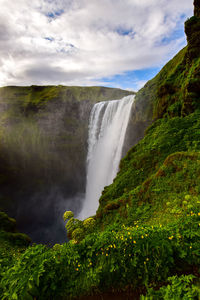 Scenic view of waterfall against sky